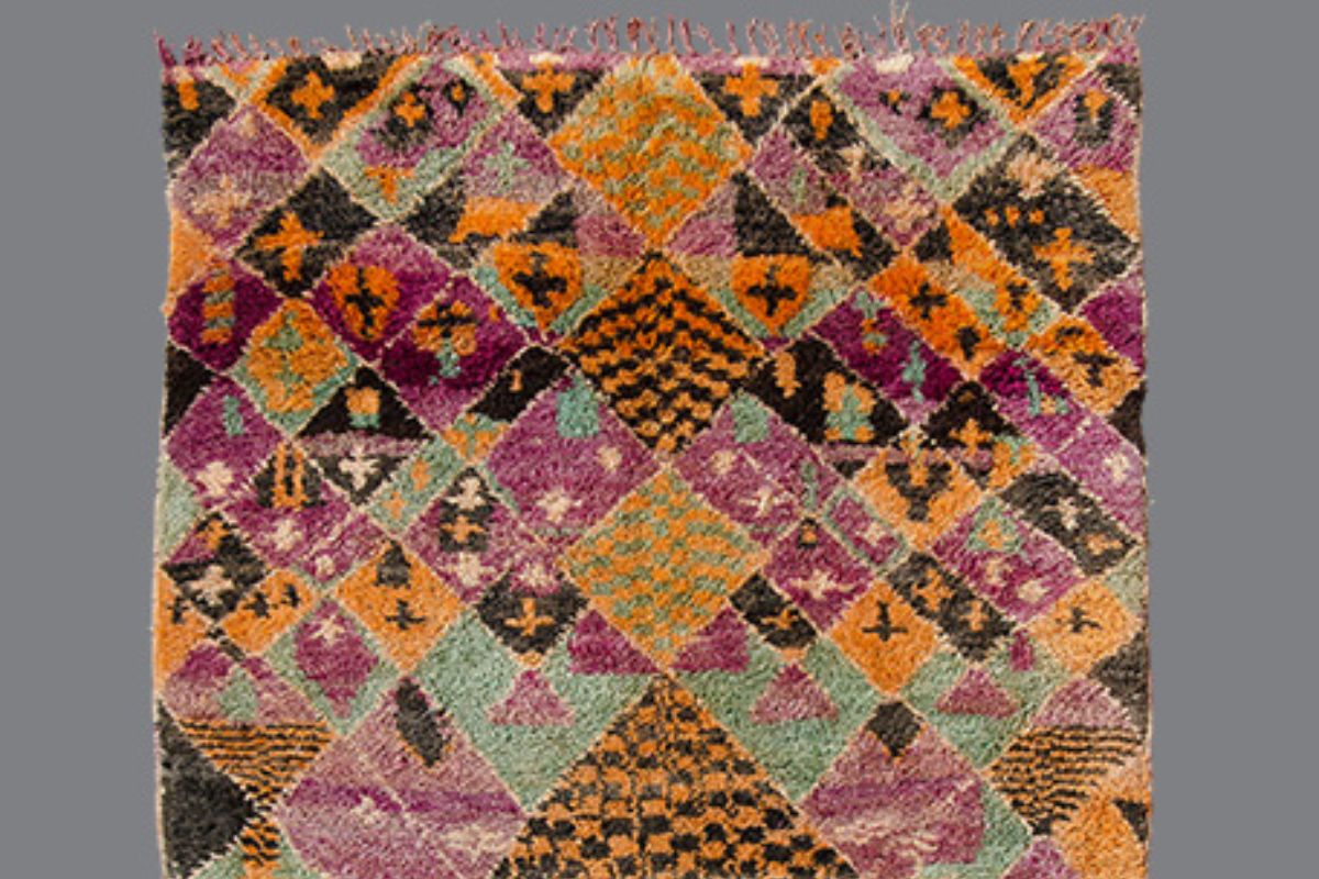Ait Bou Ichaouen Rug: Morocco's Eastern Outlier Aït Bou Ichaouen or Talsint wool rug with densely packed magenta, orange, sage-green, ochre, and charcoal geometric motifs.
